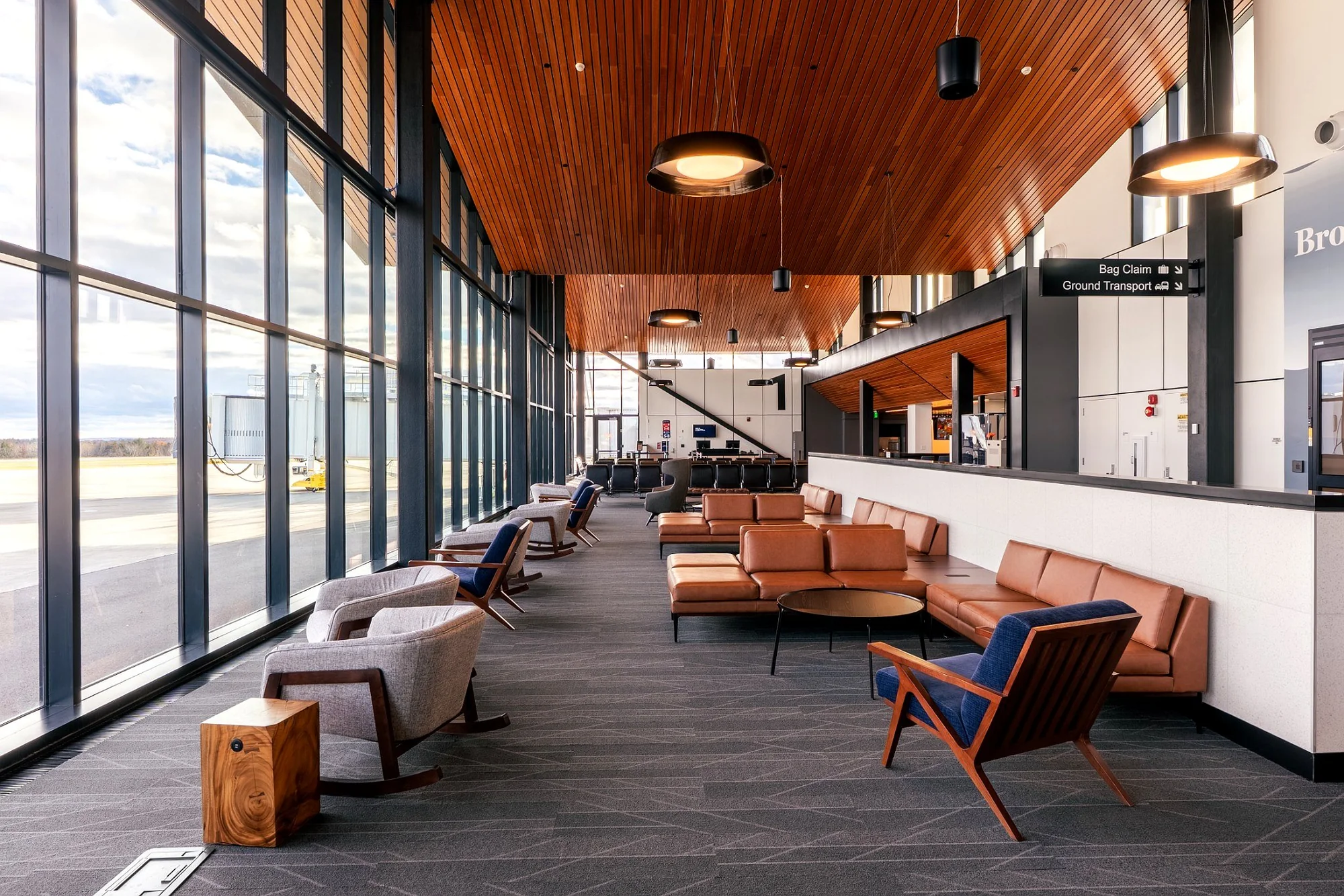 Commercial lounge furnishings with upholstered seating, tables and wood accents